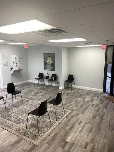 Brightly lit group therapy room at MAT Texas detox center in Dallas with chairs arranged on a patterned rug.