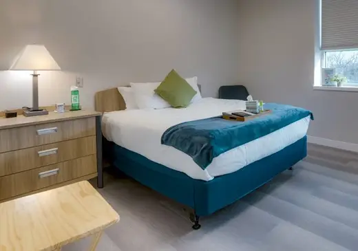 Cozy bedroom with a large bed at Gallus Detox Dallas, a detox center in Dallas.