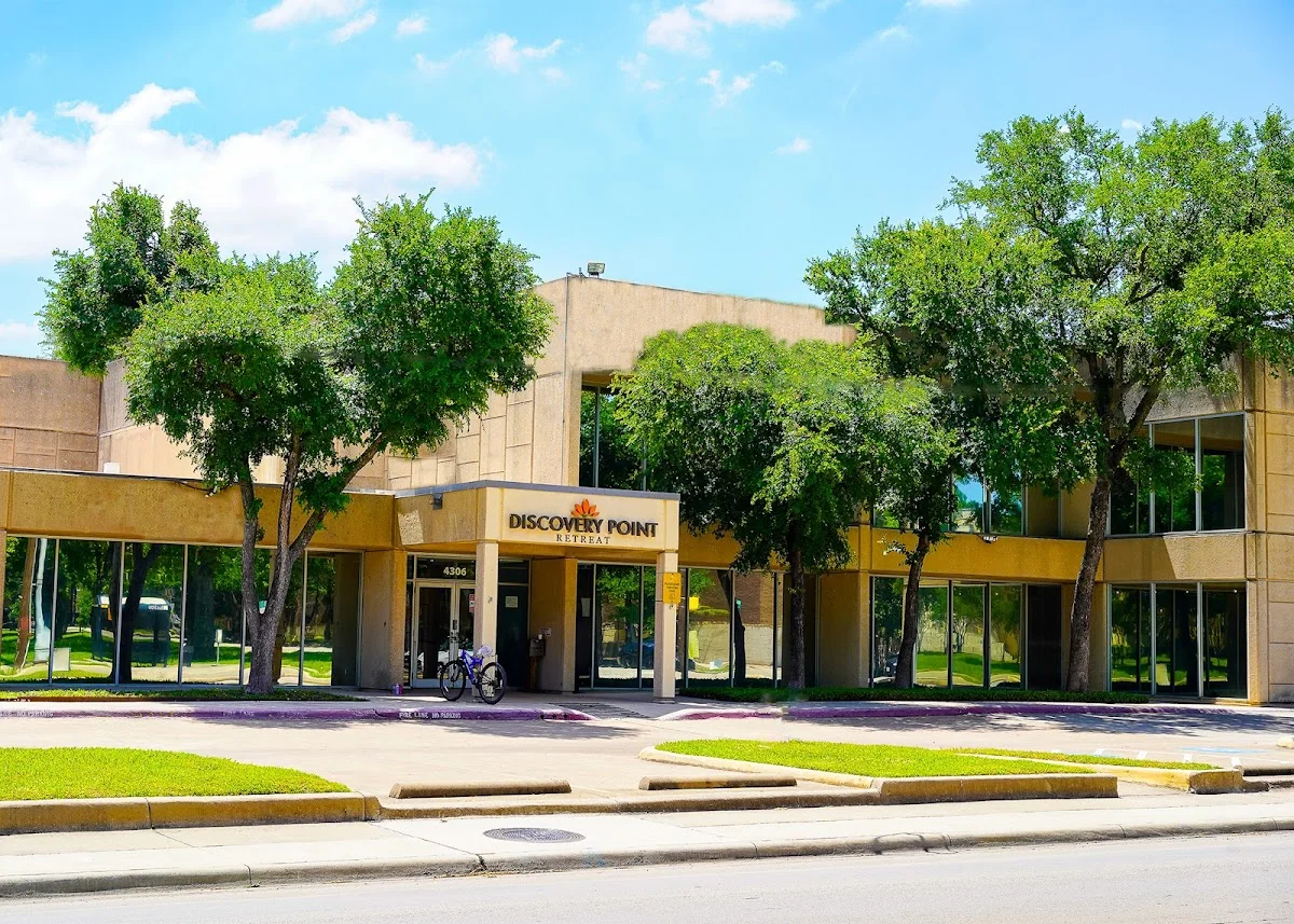 Modern building entrance with trees at Discovery Point Retreat, an intensive outpatient program in Dallas.