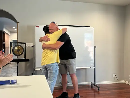 Supportive group hug in a welcoming space at Hope is Alive, a sober living home in Dallas.