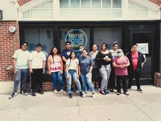 Group of residents outside Noble Life Outreach sober living home in Dallas.